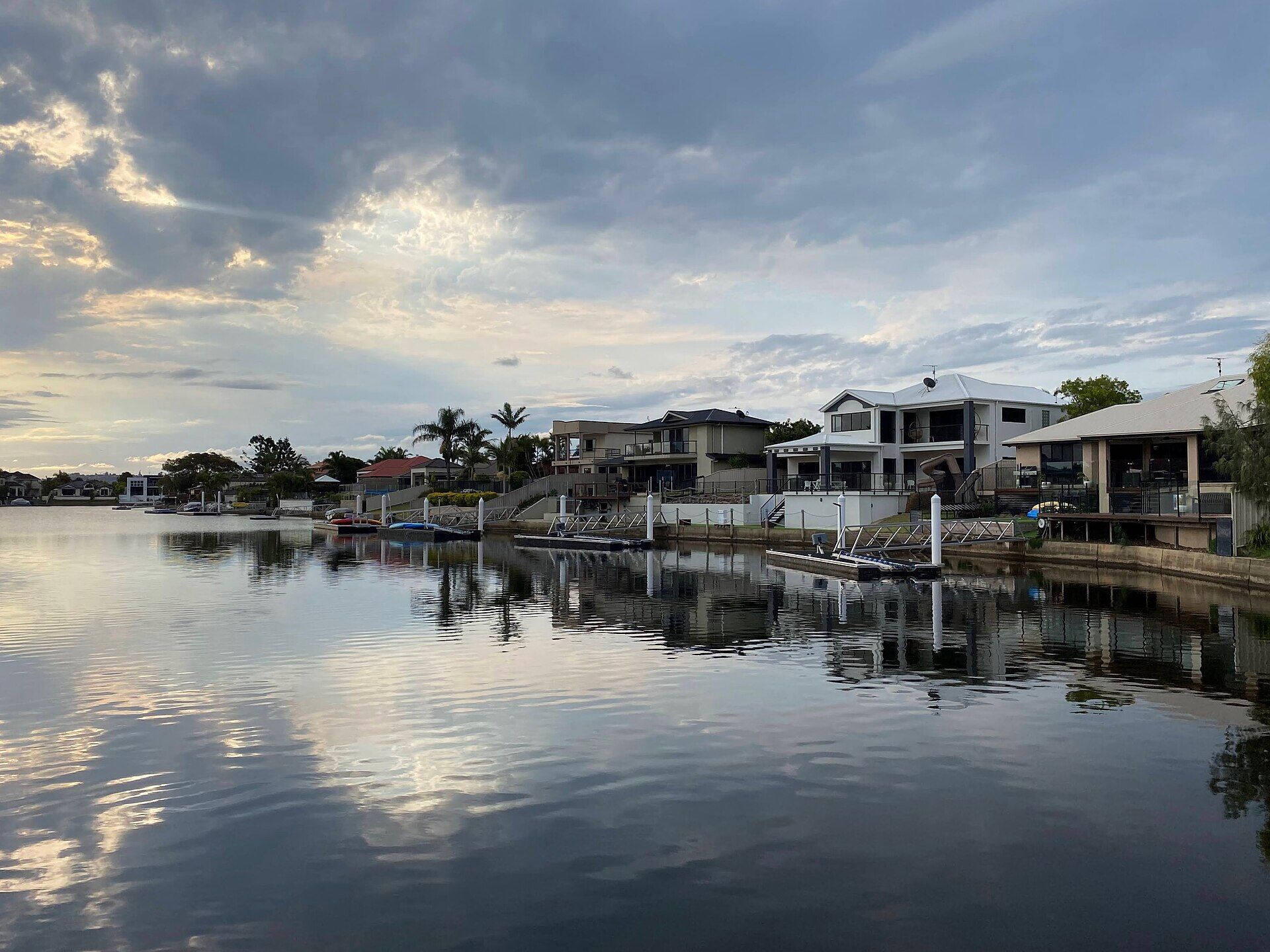 Canal-front homes reflected in the water at Parrearra