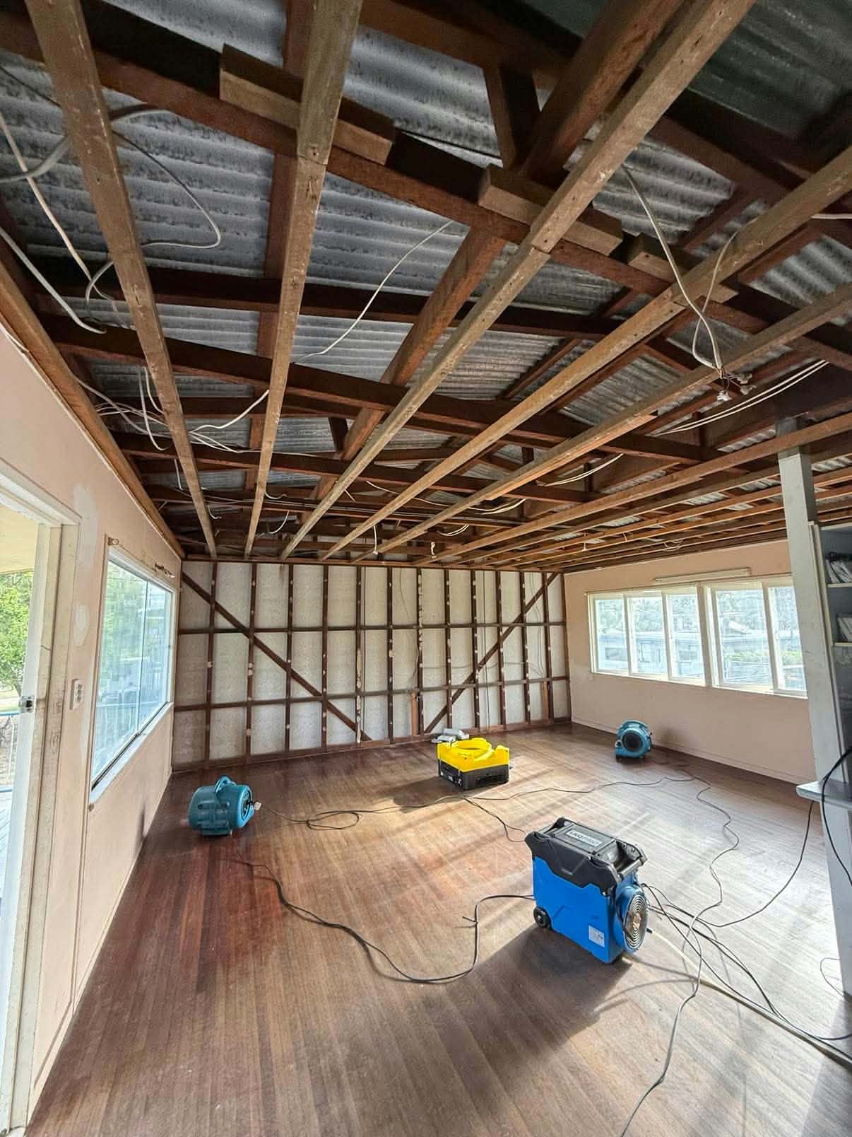 Ceiling and wall strip-out with drying equipment on timber floors, ready for relining by K & J Interior Linings